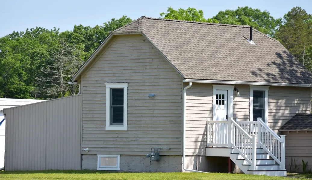 White seamless gutter and downspout on a weathered tan South Jersey clapboard home