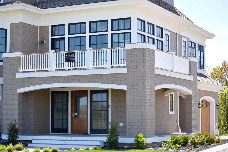 White seamless gutters on a taupe shingle Cape May, NJ home with covered porch