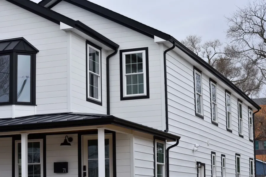 Black seamless gutters on a white two-story home in Northfield, NJ