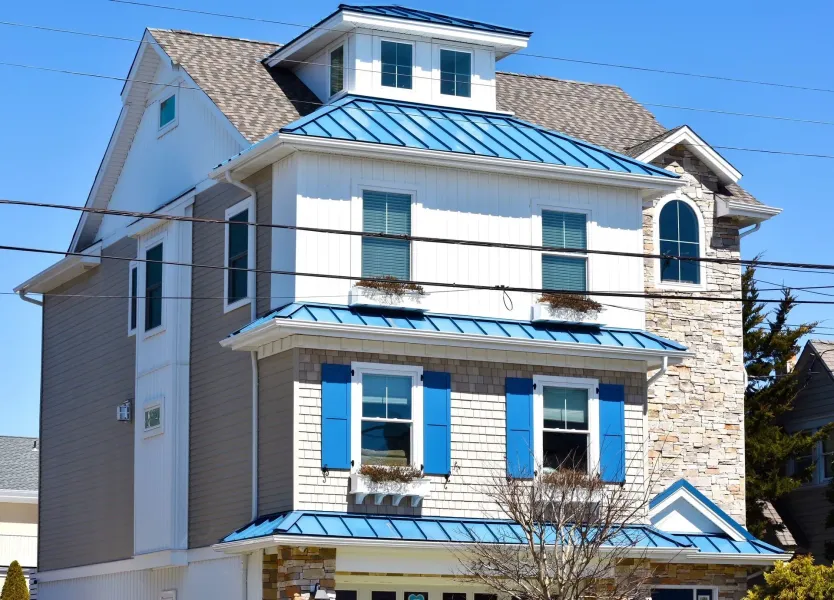 Three-story home with blue metal roofs and seamless gutters in Ocean City, NJ