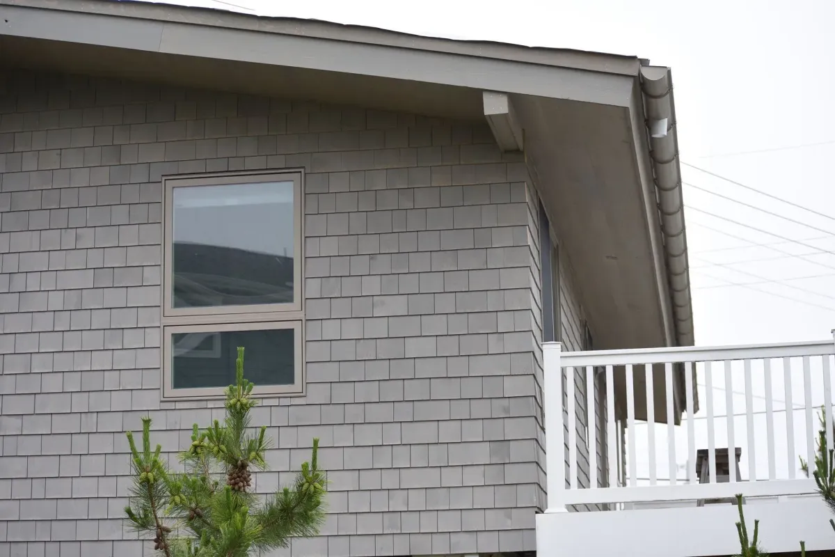 Gray seamless gutter along the gable roofline of a shingle-sided home in Williamstown, NJ