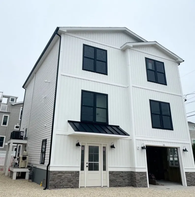 White seamless gutters and black downspout on a modern coastal home in Sicklerville, NJ