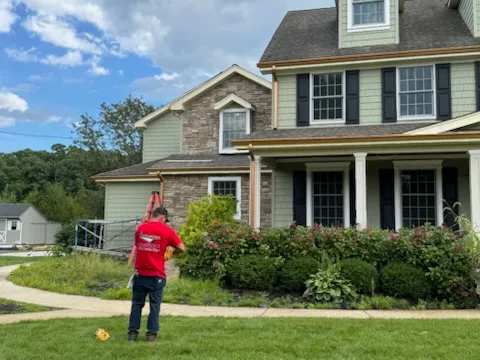 Apex Gutters technician at a stone-front colonial home in West Berlin, NJ