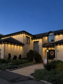 Permanent roofline lighting on a stucco home near West Berlin, NJ at dusk